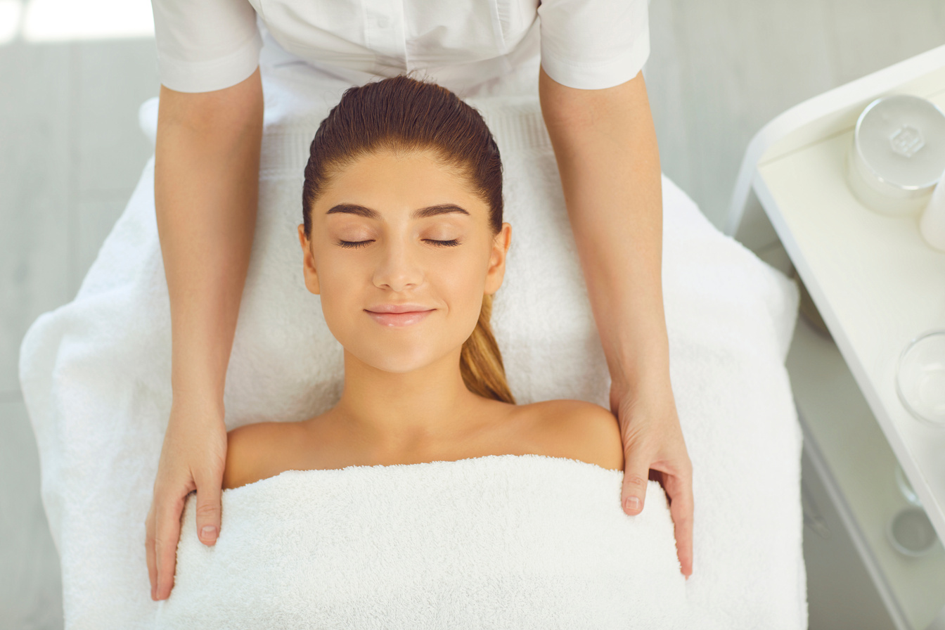 Caucasian Young Woman Receiving Head, Neck and Shoulder Massage at Wellness Spa.